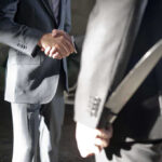 Two men shaking hands one holding hidden knife